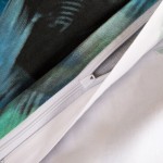 Pościel satyna bawełniana 160x200 w kolorze białym z turkusowym wzorem piór. Zbliżenie na suwak oraz widoczną teksturę materiału. Komplet leżący płasko, odsłaniający wewnętrzną stronę poszewek. Idealna do podkreślenia eleganckiego wystroju sypialni.