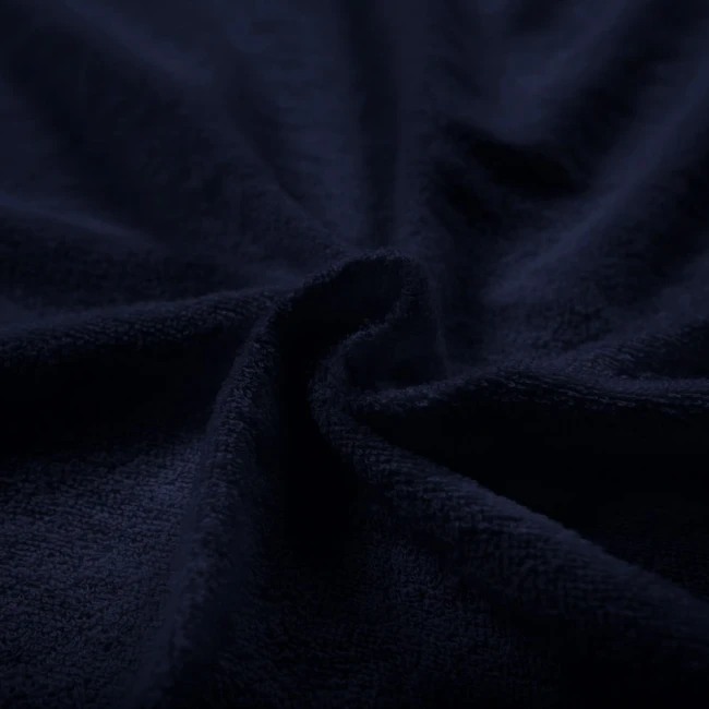 Pościel frotte w kolorze ciemnego granatu o wymiarach 160x200 cm, widoczna miękka faktura materiału, ułożona w falach, co podkreśla jej przyjemność w dotyku i stylowy wygląd.