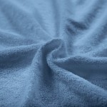 Pościel frotte 160x200 w kolorze błękitnym, z miękką, teksturowaną powierzchnią. Ułożona w rozciągniętej pozycji, z wyraźnie widoczną fakturą materiału. Tło proste, co podkreśla kolor i jakość tkaniny.