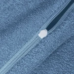Frotte pościel w kolorze błękitnym, z widocznym zamkiem błyskawicznym. Ujęcie z bliska, ukazujące teksturę materiału oraz detale zamka. Produkt złożony, na jednolitym tle.