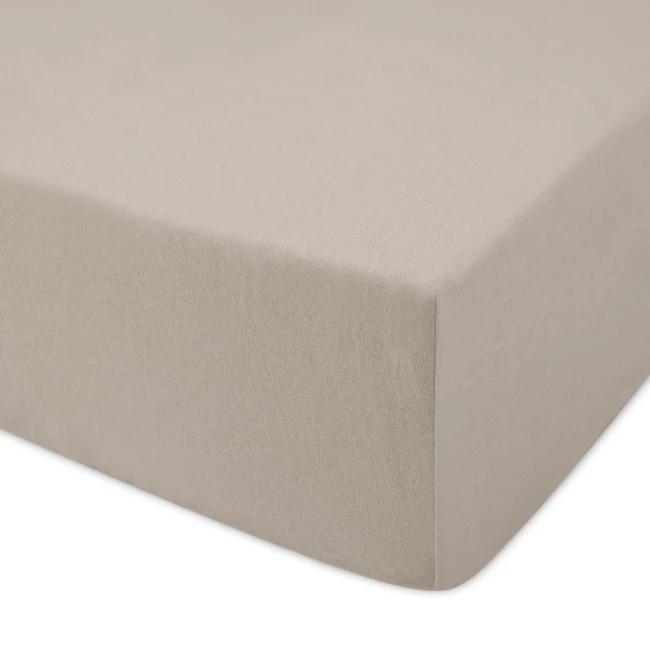 Prześcieradło jersey z gumką 120x200 w kolorze kakao, leżące na białym tle. Materiał ma gładką teksturę, z wykończeniem na brzegach. Widoczny kształt z zaokrąglonymi rogami, idealne do łóżka o standardowych wymiarach.