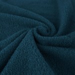 Komplet ręczników z bawełny Solano w ciepłym odcieniu ciemnego błękitu, z fakturą pętelkową. Złożone w stylowy sposób, ukazują miękkość materiału. Widoczne detale to delikatne wykończenia z brzegów. Zdjęcie na jednolitym tle.