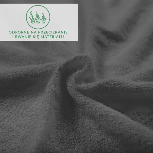 Frotte prześcieradło z gumką w kolorze ciemnoszarym, rozłożone w sposób widoczny, z wyraźną teksturą materiału. W zbliżeniu na delikatne włókna, obraz ukazuje też logo odporne na przecieranie.