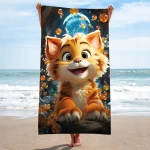 Ręcznik plażowy 100x180 cm z mikrofibry, z wizerunkiem uśmiechniętego, rysunkowego kota na kolorowym tle z bąbelkami. Produkt trzymany w pionie, na plaży, w tle morze i niebo. Idealny do użytku nad wodą.