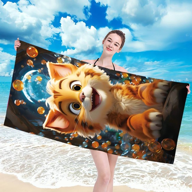Ręcznik plażowy 100x180 cm z motywem kotka, wykonany z szybkoschnącej mikrofibry. Na zdjęciu trzymany przez osobę stojącą na plaży, z błękitnym niebem i morzem w tle. Kolory jasne i żywe, z wyraźnym obrazem kota wśród bąbelków.