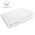 Flanelowe prześcieradło z gumką w rozmiarze 120x200 cm, w kolorze białym. Leżące na białym tle, widoczne złożenia materiału. Produkt wykonany z tkaniny o gramaturze 160 g/m2, z napisem Nie mechaci się w zielonym kolorze.