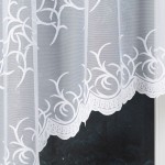 Firana gotowa BAKARO żakardowa, 320x160 cm, biała, z misternym wzorem roślinnym, zawieszona na karniszu. Materiał delikatny i półprzezroczysty, z falbaniastym dołem. Tło: ciemne, co podkreśla jasność firany.
