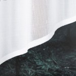 Firana gotowa DANIELA, żakardowa, biała, o wymiarach 300x140 cm, zdjęcie ukazujące dolną część firany z delikatną, przejrzystą fakturą. Produkt leży na ciemnym tle, co podkreśla jego kolor. Widoczny jest gładki, estetyczny brzeg firany.