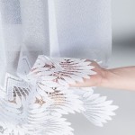 Firana gotowa FELICJA żakardowa, biała, z delikatnym wzorem liściowym na dole, rozłożona na ręce. Zbliżenie na teksturę materiału, z przezroczystą strukturą, co pozwala na przepuszczanie światła. Wymiary: 300x160 cm.