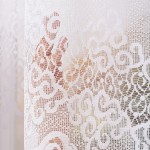 Firana gotowa MODESTA żakardowa, biała, o wymiarach 400x160 cm, w formie zwisającego panelu. Wzór z delikatnymi motywami roślinnymi, widoczna tekstura materiału. Ujęcie zbliżeniowe, ukazujące szczegóły splotu na tle rozmytego otoczenia.