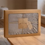 Pościel bawełniana z falbanką 220x200 w kolorze żółtym, zapakowana w eleganckie pudełko z oknem. Widoczna metka z logo LIMASSO oraz informacje o kolekcji. Pudełko na drewnianym stole w jasnym wnętrzu.