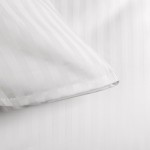 Pościel hotelowa bawełniana 160x200 w pasy 1cm w kolorze białym, z zakładką 30 cm. Widoczna struktura materiału oraz detale brzegów poszewek. Ujęcie z boku, zbliżenie na poszewkę poduszki, na jasnym tle.