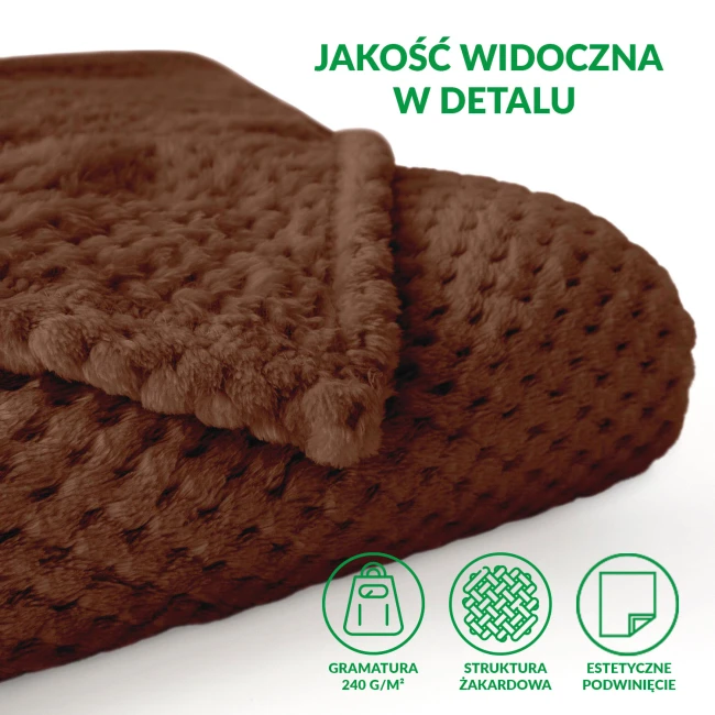 Koc żakardowy 150x200 w kolorze mlecznej czekolady, leżący na jasnym tle. Widać jego miłą, teksturowaną powierzchnię oraz staranne wykończenie brzegów. Rozmiar i faktura podkreślają jego elegancję i funkcjonalność.
