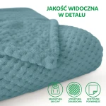 Koc żakardowy 150x200 w jasnym turkusowym kolorze, rozłożony na jednolitym tle. Wyróżniająca się teksturowana powierzchnia z drobnym wzorem. Widoczna krawędź z podwinięciem, co podkreśla jego miękkość i komfort.