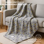 Puszysty koc dekoracyjny 200x220 cm w jasnoszarym kolorze z wzorem w żółte i brązowe kropki. Koc leży na kanapie, prezentując miękką teksturę, idealny do użytku na sofie lub łóżku.