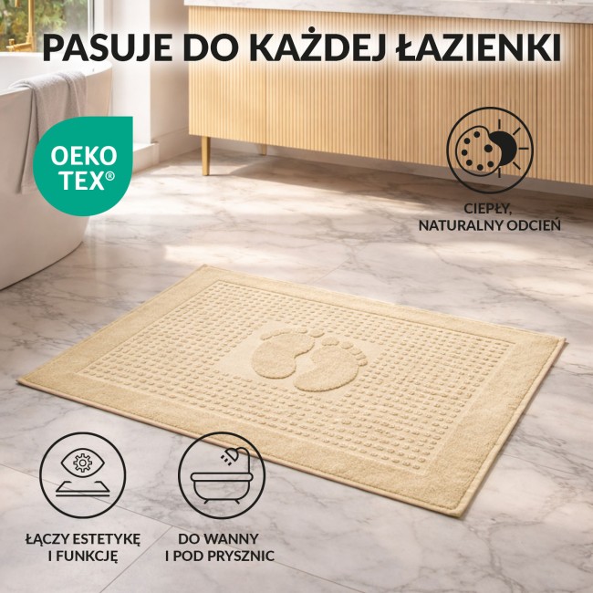 Dywanik łazienkowy 50x70 w kolorze kremowym, o gładkiej fakturze, leżący na podłodze. Otoczenie to nowoczesna łazienka