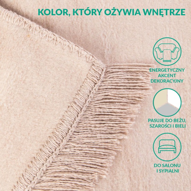 Koc bawełniany w jasnym beżu, o wymiarach 150x200 cm, z detalami frędzli. Zbliżenie na krawędzie z delikatnym przeszyciem, wyraźna, miękka tekstura tkaniny, układ leżący. Tło jednolite, podkreślające kolor i detale produktu.