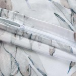 Pościel satyna bawełniana 140x200 Azura w białym kolorze z delikatnym wzorem niebieskich liści. Widoczny zamek błyskawiczny na poszewce, gładka faktura materiału, idealna do eleganckich aranżacji sypialni.
