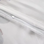 Pościel satyna bawełniana 180x200 w kolorze białym z dużymi pastelowymi niebieskimi kwiatami. Zamek błyskawiczny na poszewce, gładka tekstura materiału, idealna do sypialni.