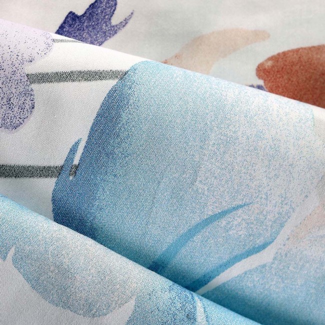 Pościel satynowa w kolorze białym z dużymi pastelowymi niebieskimi kwiatami. Materiał bawełniany o gładkiej fakturze. Widoczny detal kwiatów w odcieniach niebieskiego i fioletowego, układ tkaniny w złożeniu. Rozmiar 220x200 cm.