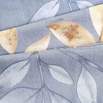 Pościel bawełniana 140x200 Sandleaf w niebieskim kolorze z beżowymi liśćmi. Widoczny delikatny wzór liści na miękkiej, gładkiej tkaninie. Położona na sobie, z wyraźnymi detalami i fakturą materiału.