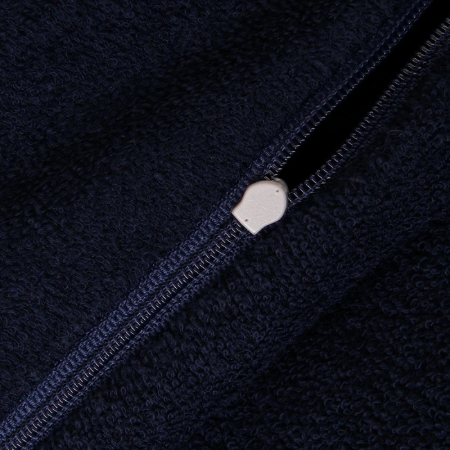 Pościel frotte w kolorze ciemnego niebieskiego, granatowego z widocznym zamkiem błyskawicznym. Materiał o miękkiej, teksturowanej powierzchni, podkreślającej właściwości komfortowe. Ujęcie z bliska na detal zamka.