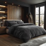 Poszewka frotte 40x80 w kolorze ciemno szarym, antracytowym, leżąca na poduszce w eleganckiej sypialni z drewnianą ścianą i nowoczesnym łóżkiem. W tle widoczne dekoracyjne oświetlenie i zasłony.