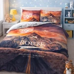 Pościel bawełniana 160x200 cm w motywie górskim z zachodem słońca, z nadrukiem ROUTE na narzucie i poszewkach. Kolory: pomarańczowy, fioletowy i niebieski. Pościel z zamkiem błyskawicznym, rozłożona frontalnie w pięknej sypialni dziecięcej.