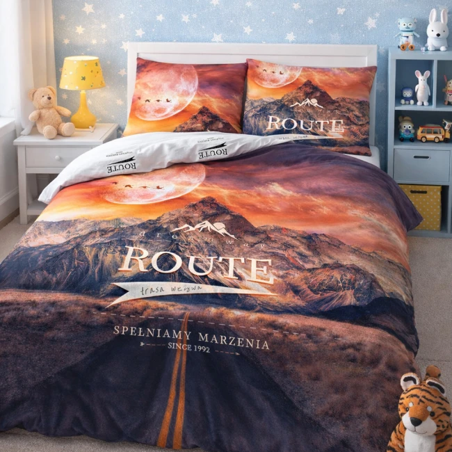 Pościel bawełniana 160x200 cm w motywie górskim z zachodem słońca, z nadrukiem ROUTE na narzucie i poszewkach. Kolory: pomarańczowy, fioletowy i niebieski. Pościel z zamkiem błyskawicznym, rozłożona frontalnie w pięknej sypialni dziecięcej.