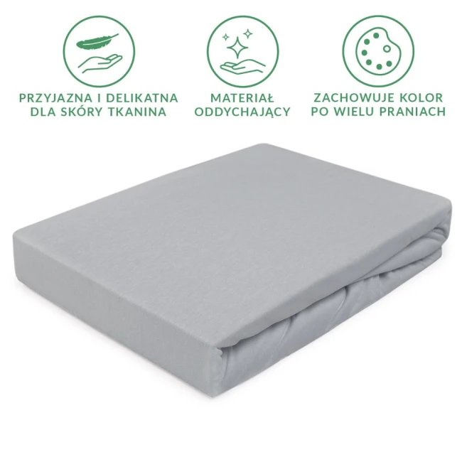 Prześcieradło jersey z gumką w kolorze popielatym, rozmiar 60x120 cm, leżące na gładkim tle. Wykonane z delikatnego, oddychającego materiału, z widocznymi fałdami tkaniny. Brak napisów lub logo na powierzchni.